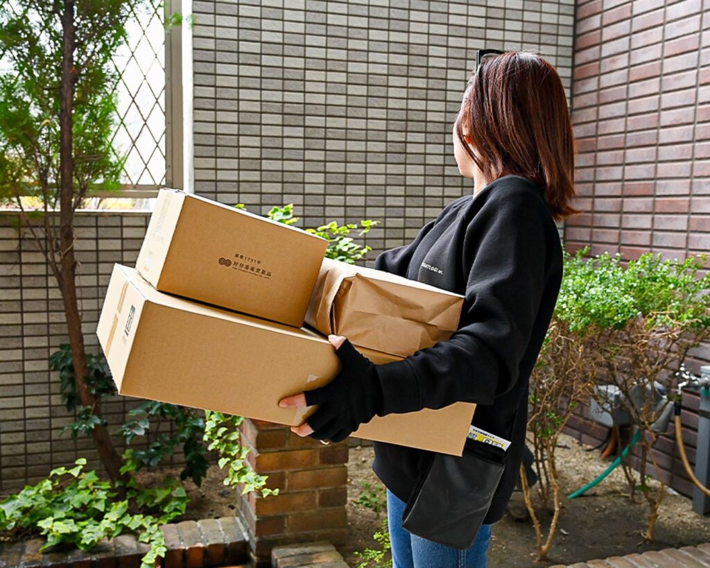 段ボールの荷物を配達する女性