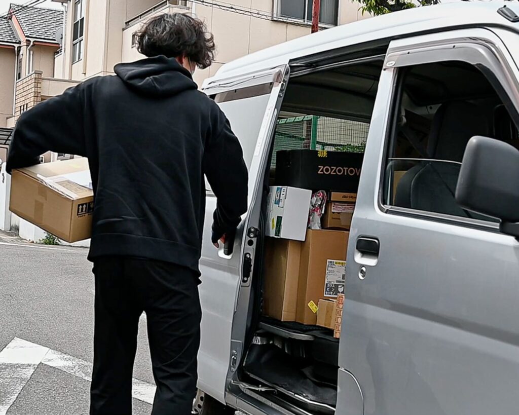 軽トラから荷物を取り出す男性